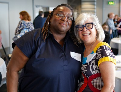 Two women are looking at the camera and smiling