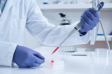 Scientist in lab with blood sample - stock image